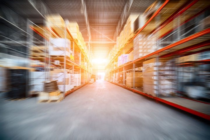 Warehouse industrial and logistics companies. The boxes on high shelves stocked. Motion blur effect. Bright sunlight.